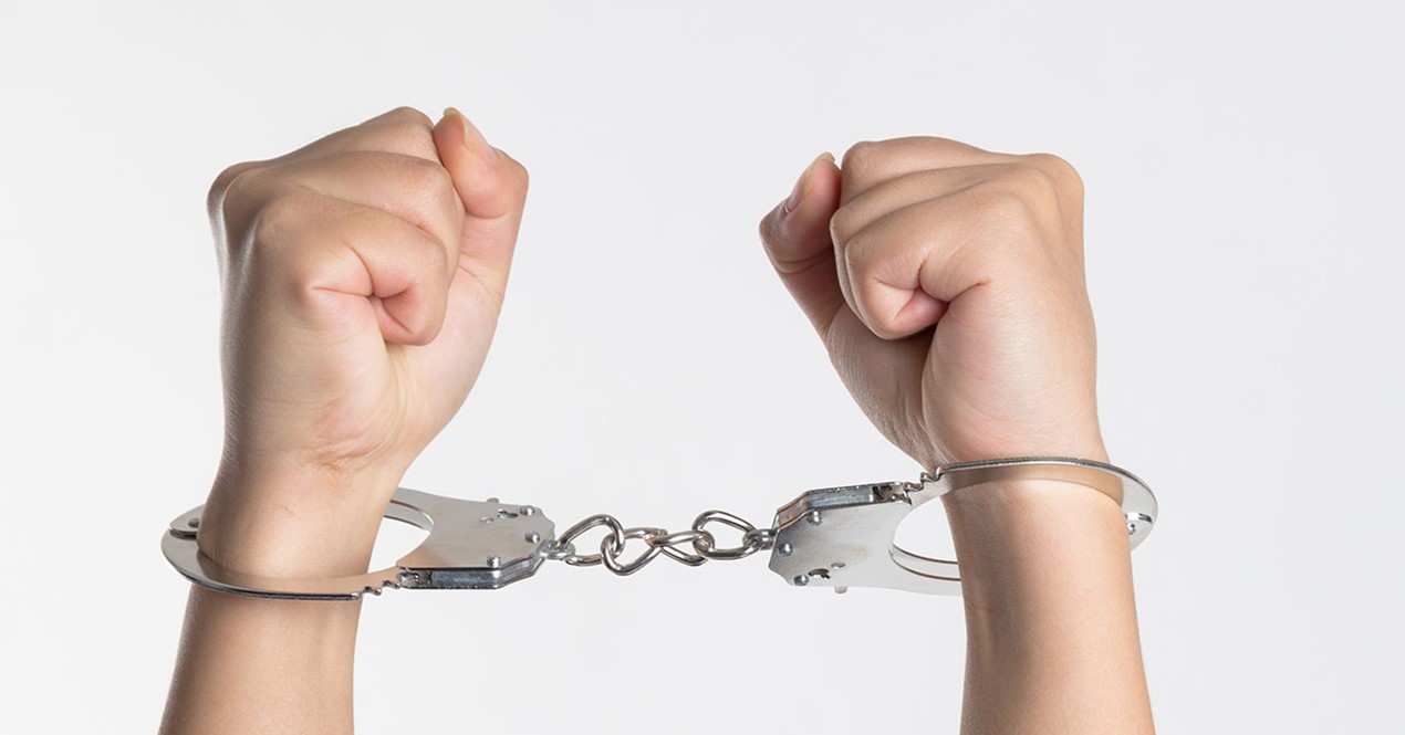 Bilde av hender lenket sammen med håndjern