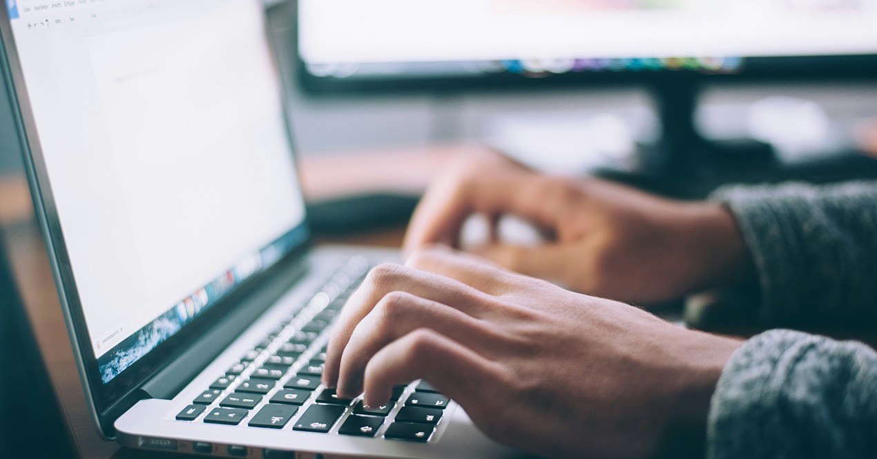Bilde av en person foran en laptop