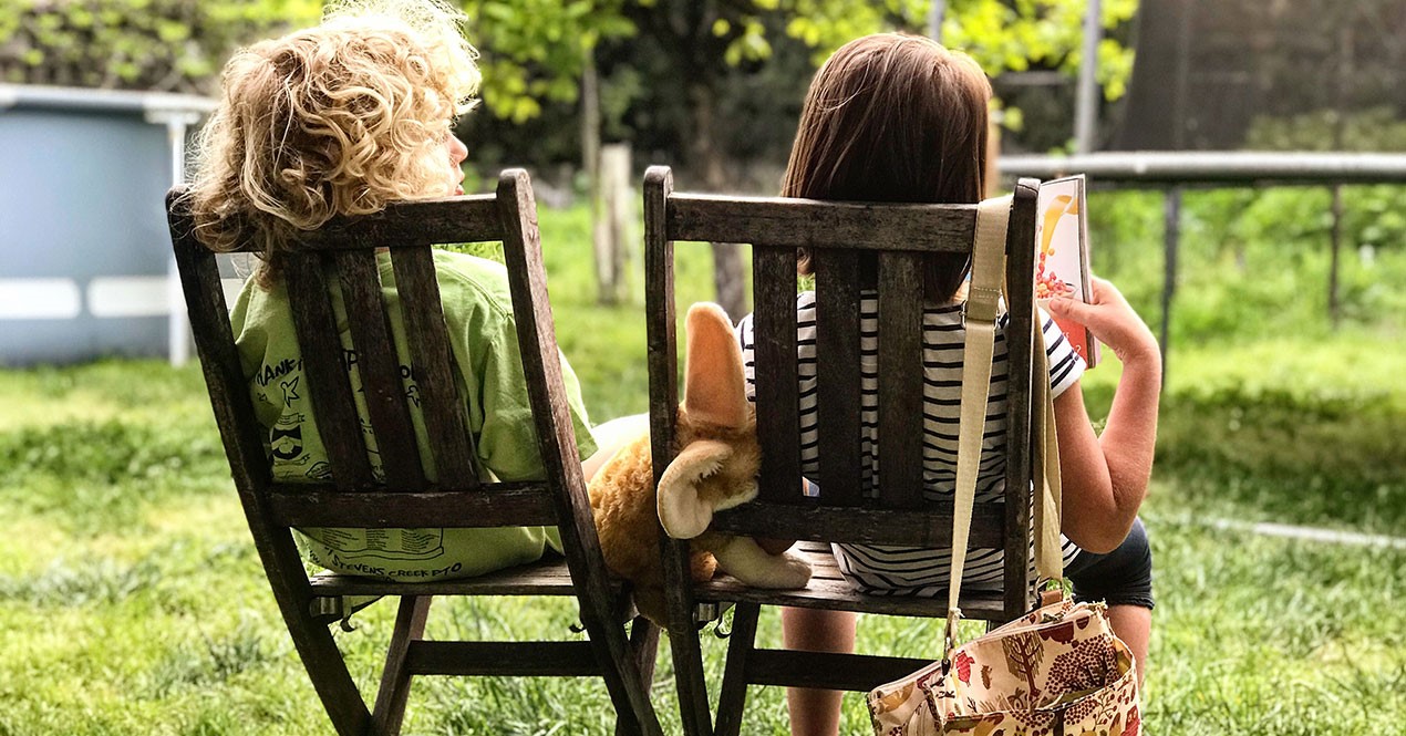 Bilde av to små barn som sitter i en grønn hage og filosoferer over livet.